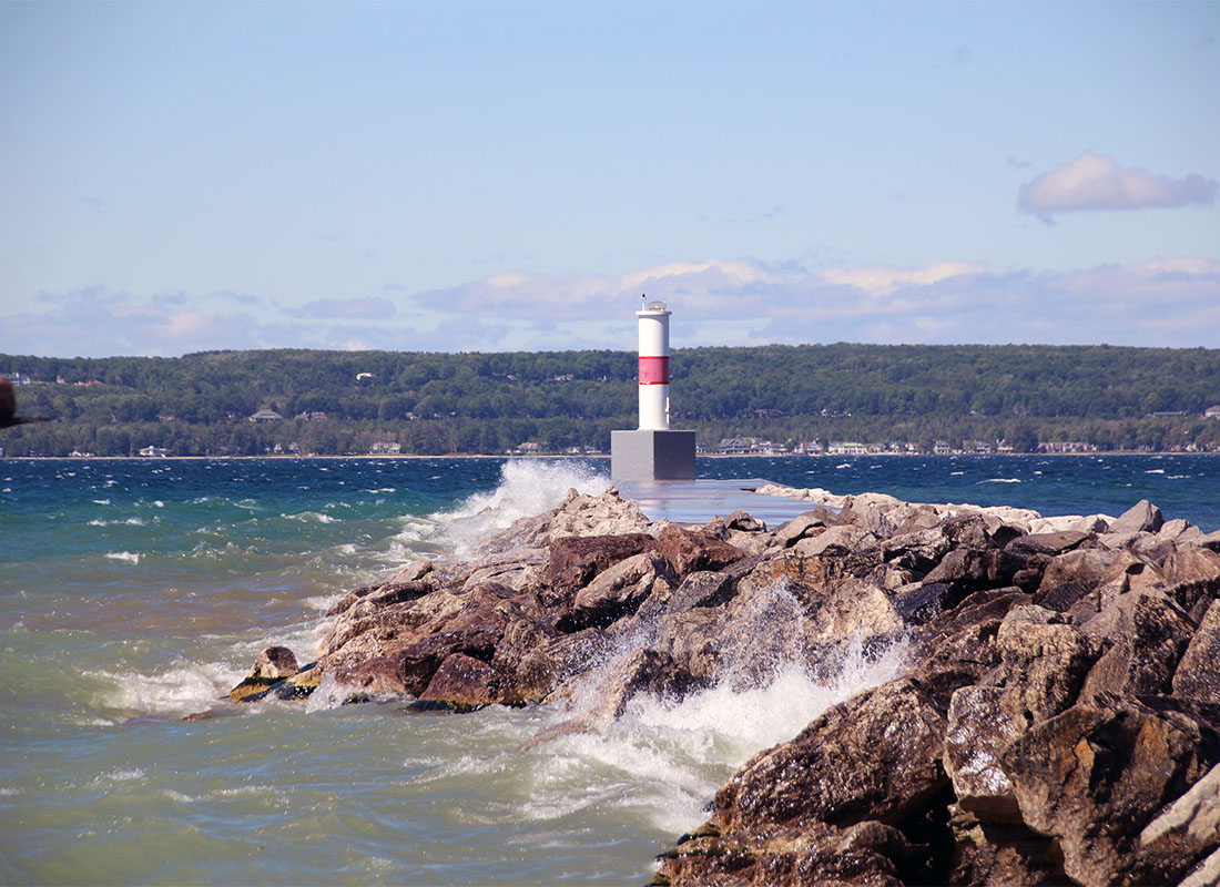Service Center - View of a Lighthouse on the Edge of a Rocky Cliff on Lake Michigan with Rough Water on a Sunny Day
